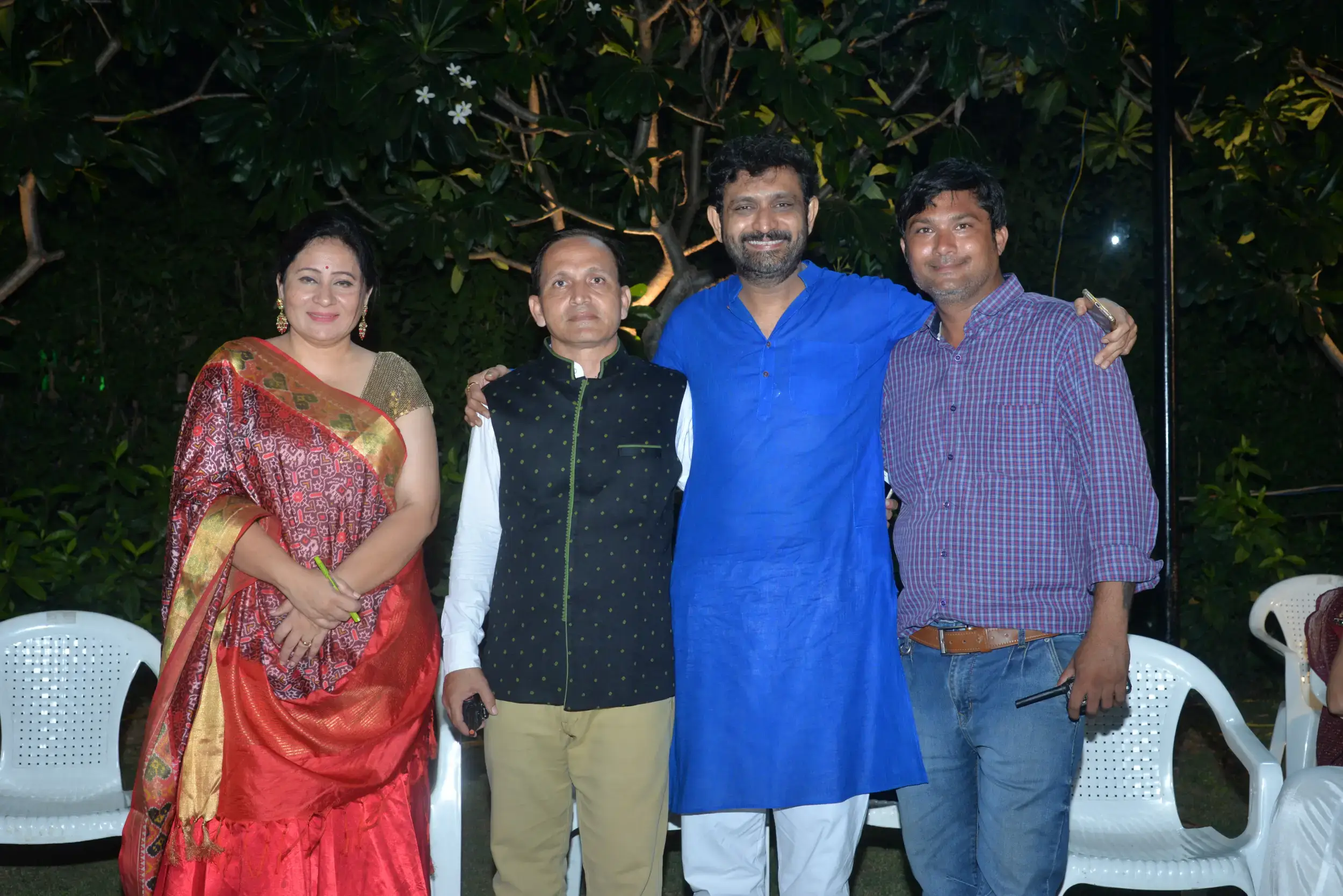 Group of men posing with large cartoon character inflatable figures at night outdoors